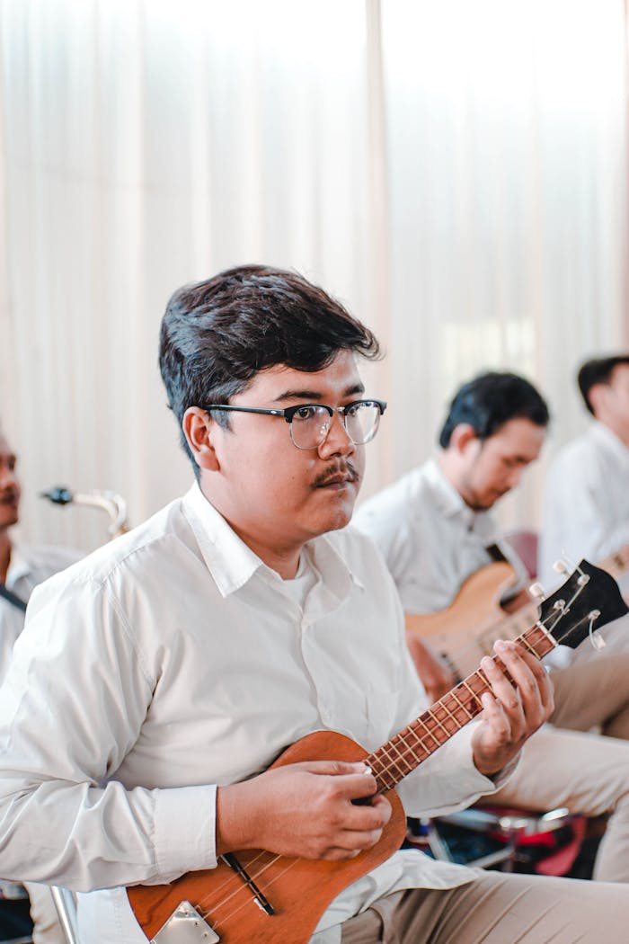 Man in White Shirt Playing Guitar